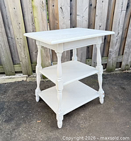 Full view of side table showing three tiers and turned legs