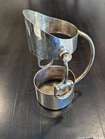 Front three-quarter view showing upper neck ring, lower base cup and handle