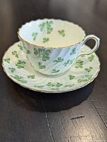 Teacup on saucer showing pattern, shape and gilt trim