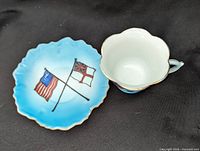 Teacup and saucer front showing flag motif and blue gradient