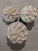 Top view showing sculpted flower lids on three jars