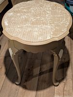 Full view of round scalloped-edge end table showing legs and finish