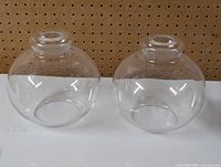 Front view of two clear glass globe lampshades