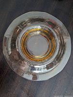 Top view of circular smoky amber glass platter showing central dip recess
