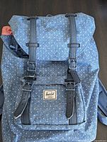 Front view of blue polka-dot Herschel backpack showing overall design and branding