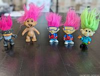 Group shot of five troll dolls with varying hair colors and outfits