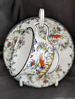 Teacup hanging in front of saucer showing exterior pattern
