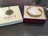 Bracelet in gift box beside box lid showing "Gift It from Belk" branding