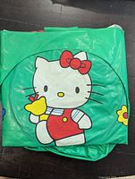 Deflated green Hello Kitty inflatable chair showing front graphic