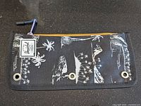 Front view of Herschel pencil case showing print, zipper, label, and grommets