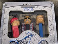 Front view of sealed OCC PEZ tin showing three character dispensers through window