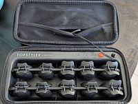 Open Topstyler case showing ten curlers on heating rails, power cord, brand marking