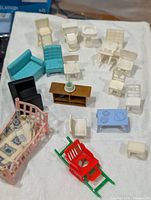 Full layout of all plastic dollhouse furniture pieces on cloth background