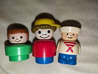 Front view of three vintage Fisher-Price Little People figures