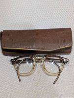 Reading glasses front view with accompanying brown hard case