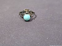 Front view of sterling silver spider ring with blue cabochon stone
