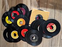 Group of roughly 14 loose 45 rpm vinyl records, one in a generic paper sleeve, assorted label colours