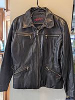 Front view of Guess black leather jacket showing overall design and zip pockets