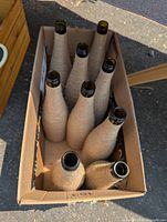 Box containing nine yarn-wrapped glass bottles