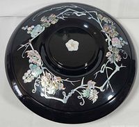 Top view of black lacquer lid showing full mother-of-pearl grapevine inlay and central blossom