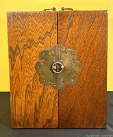 Front view of cabinet closed showing brass latch and wood grain