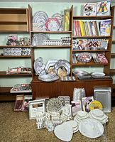 Shelving unit filled with shaped cake pans, tier plates, books, decorating accessories
