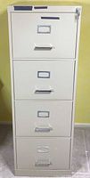 Front view of beige 4-drawer file cabinet showing handles, label frames, and lock