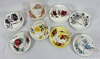 Group view of eight teacup and saucer pairs showing varied floral patterns and colours