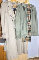 Trench coat, bomber jacket and scarf displayed on hangers