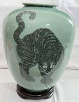 Front of celadon vase showing black cat motif