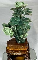 Front view of green jadeite rose carving on wood stand