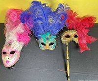 Three masks laid out showing overall designs and feather plumes