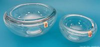 Large and small Holmegaard clear glass bowls side by side