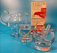 Front view of creamer, mustard pot with spoon, and mortar with pestle plus original boxes