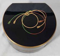 Top view of lid showing cord motif and gold edging
