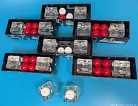 boxed and unboxed glass holders with red and white ball candles