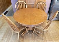 round solid oak table with four matching chairs
