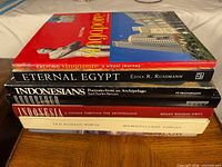 Stack of seven coffee-table books showing spines