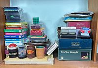 Overview of stacked board games, puzzles, dice cups, playing cards and accessories on shelf