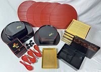 Overview showing red trays, black trays, bamboo mats, utensils, bento box
