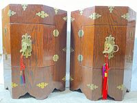 Front view of both octagonal veneered cabinets showing brass hardware and tassels