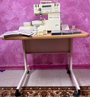 Full view of Pfaff serger on sewing table, accessories arranged