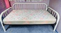 Front angled view of assembled white metal daybed with mattress