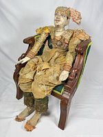 Full view of marionette seated in chair