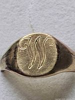 Close-up of signet face showing engraved initial