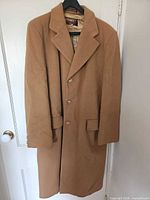Front view of camel wool overcoat on hanger