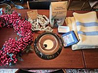 Overview of wreath, garland, glass bowl, potpourri box, wool throw and trinket dish on table