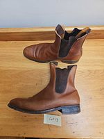 Side view of both brown leather Chelsea boots showing overall shape and condition