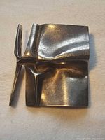 Front view showing sculptural folded design of silver brooch