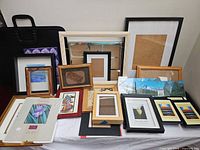 Group of assorted frames and portfolio case displayed together